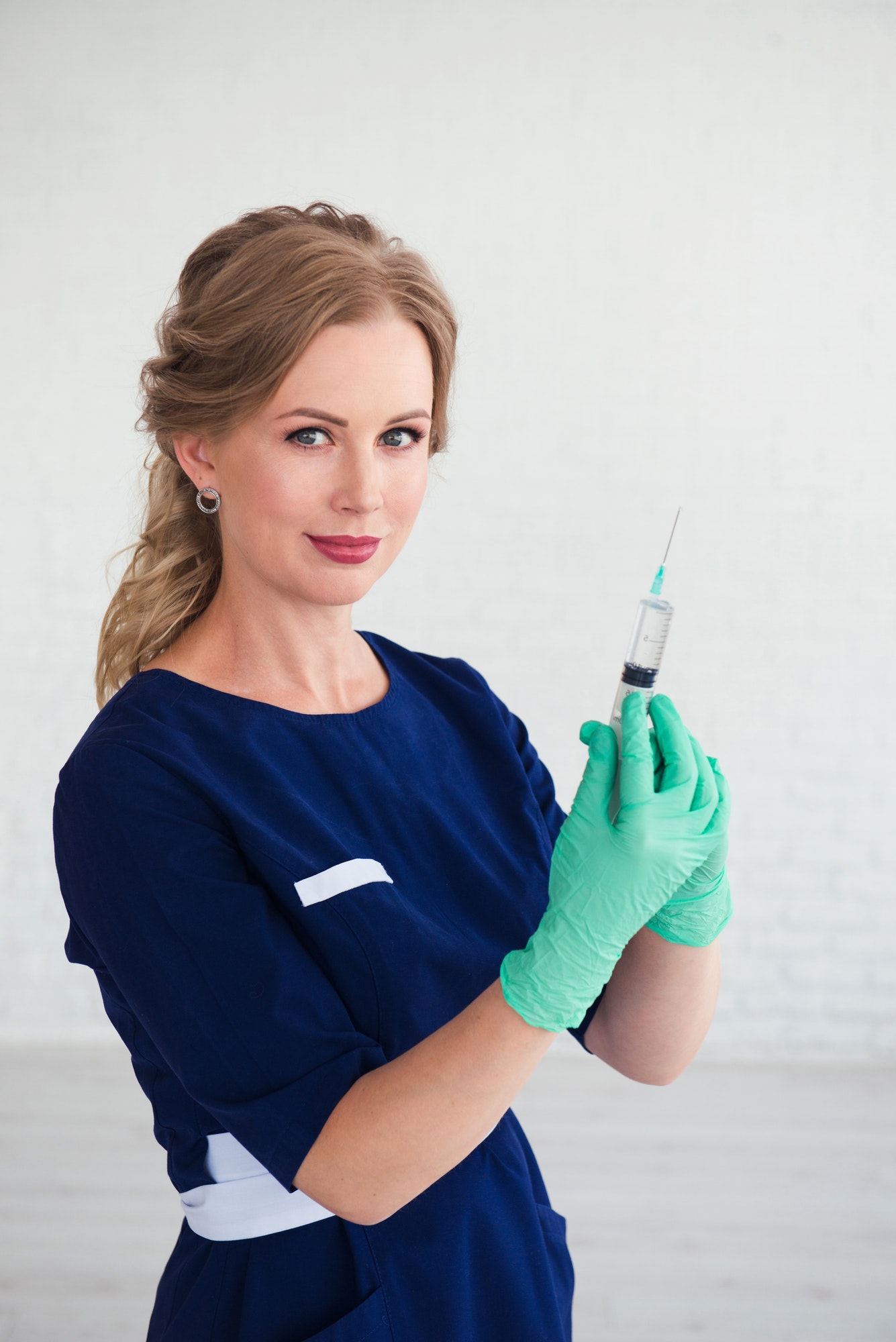 young-woman-cosmetologist-in-blue-uniform-holding-syringe-beauty-face-injection.jpg